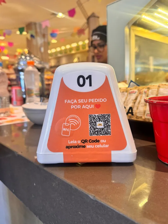 Prisma laranja de Pedido na Mesa com QR Code e NFC no balcão da padaria